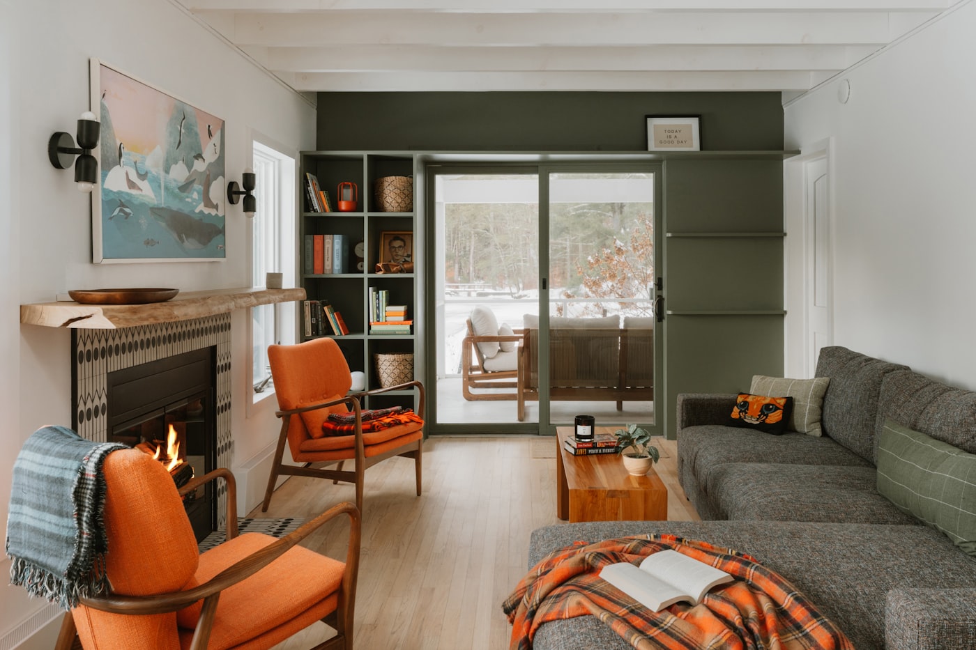 A warm Condo Life living room with orange chairs and a fireplace